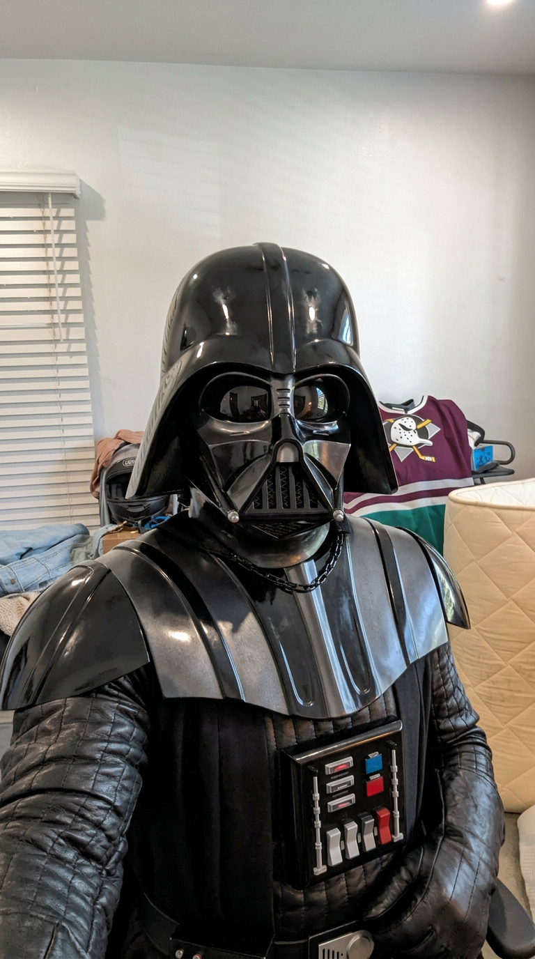 Keep the EXACT same composition, framing, camera angle, body pose, limb positions, and depth of the subject in frame as the input image. Transform the character into: Darth Vader. Replace appearance, costume, skin/fur/material, and facial features to match the new character — but the silhouette, stance, and action must be identical to the input. If the description names a scene or location, transform the background to match it; if no scene is named, keep the original background. The camera angle and subject position in frame must not move. Photorealistic where the new character allows; cinematic detail; no text or watermarks.